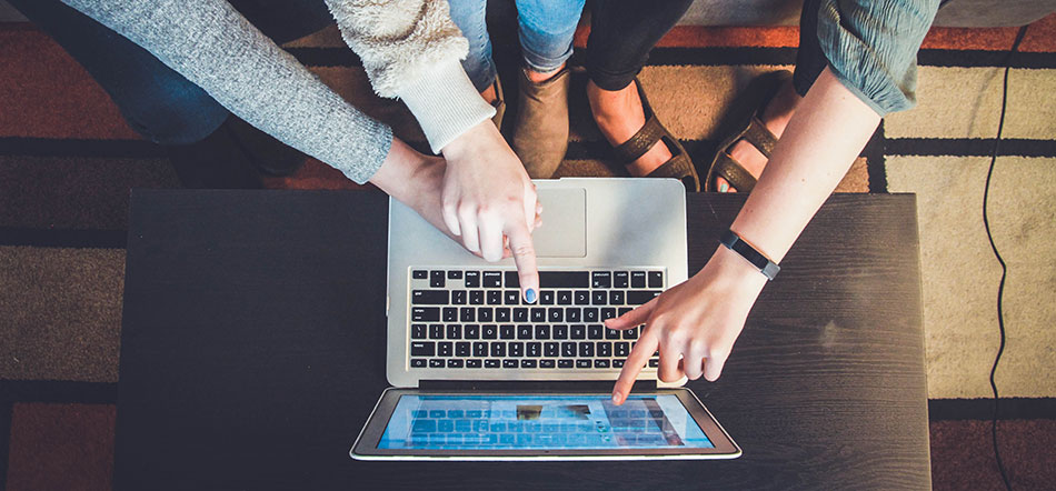 Three People Pointing Towards Laptop Screen At A New Website
