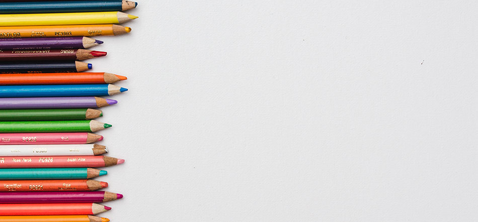Logo Redesign Colored Pencils Laid Out Over White Background