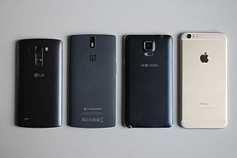 Four Smart Phones On White Background Faced Down Vertically In A Row