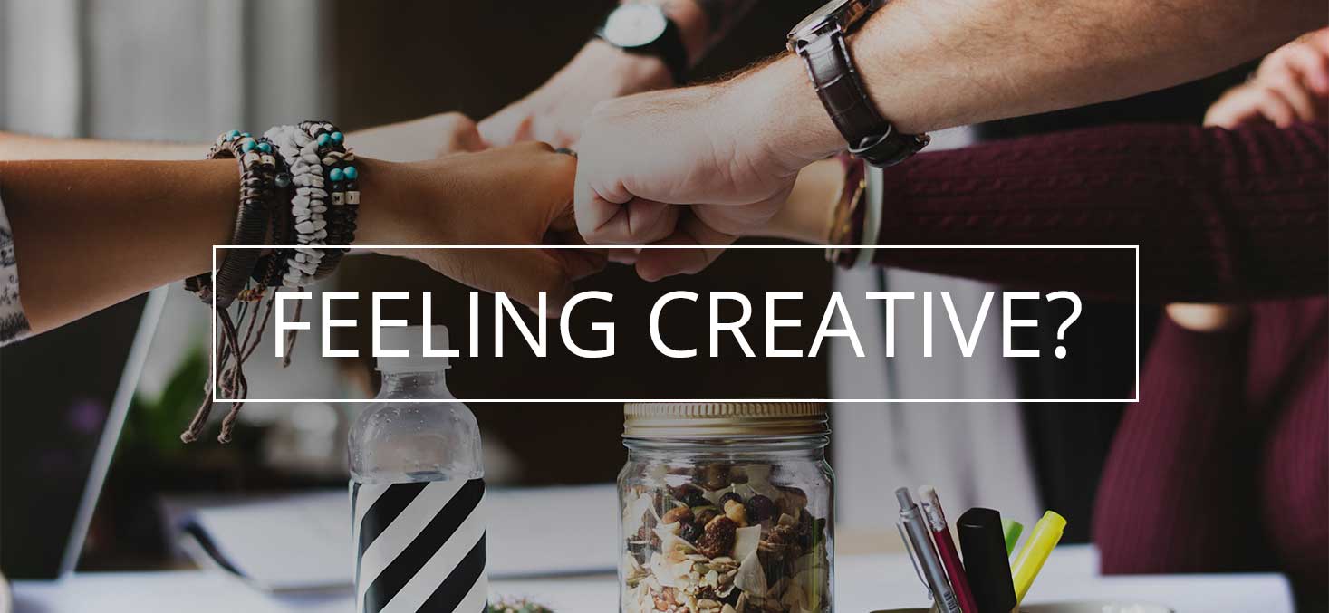 feeling creative text on top of image with 4 people holding fists together