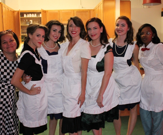image of seven women Servers in white aprons