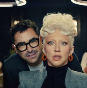 a man looking over the shoulder of a woman with bright blonde hair