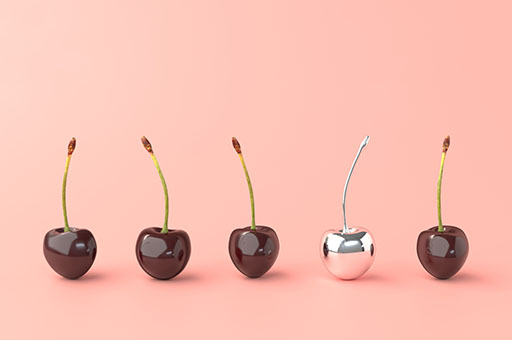 An image of five cherries with stems in a row, but the fourth one is made of shiny metal